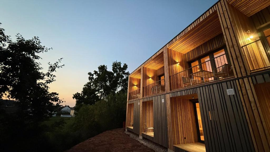 a wooden building with a balcony on the side of it at Feinzeit Naturloft - Klima, Sauna, Design in Frensdorf