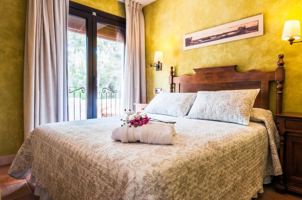 Un dormitorio con una cama con flores. en Hotel Doña Manuela, en Daimiel