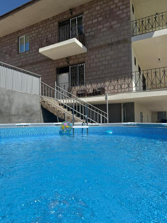 a large blue swimming pool in front of a building at Villa Garden and Pool near Airport in Norakert