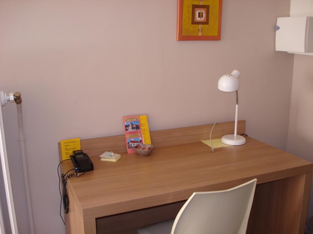 a wooden desk with a lamp and a phone on it at La Tour Des Lys in Maubeuge