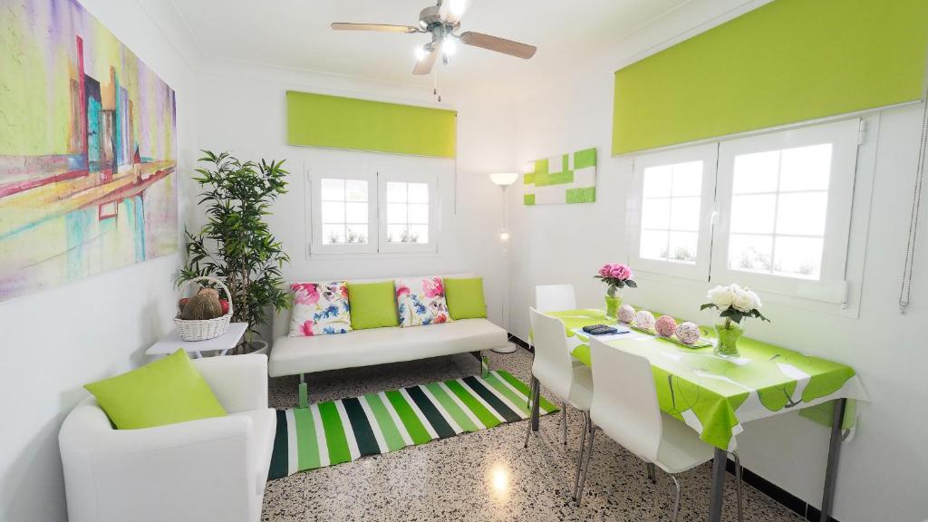 カン・ピカフォルトにあるCan Picafort 2 habsの緑と白の壁のリビングルーム(テーブル、椅子付)