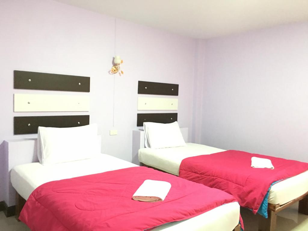 合艾的住宿－星別墅度假旅館，红色床单的客房内的两张床