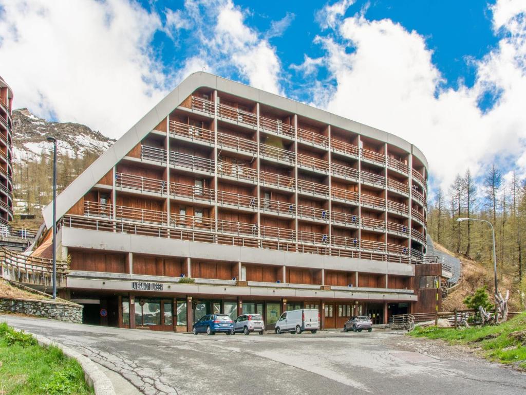 a large building with cars parked in front of it at Apartment Cervinia ski-in ski-out slopes in Breuil