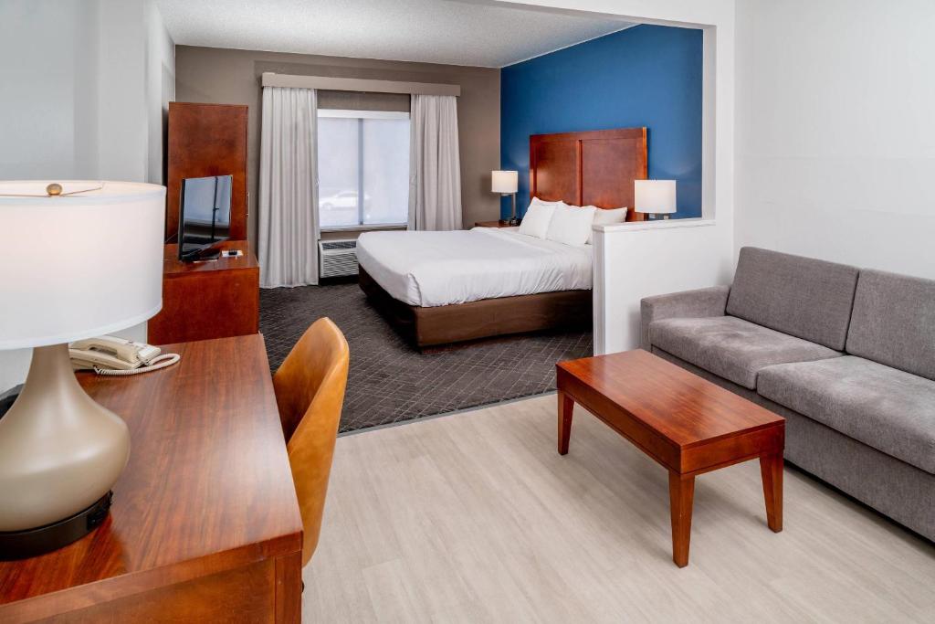 a hotel room with a bed and a couch at Comfort Suites Prestonsburg West in Prestonsburg