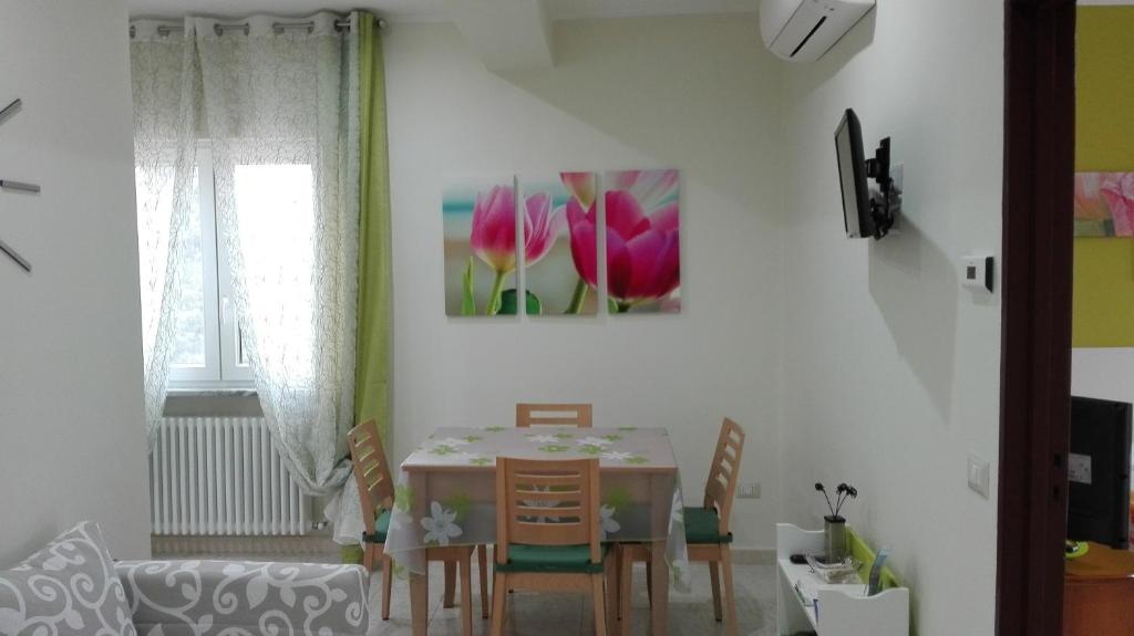 una sala da pranzo con tavolo, sedie e divano di Il Tulipano a Matera