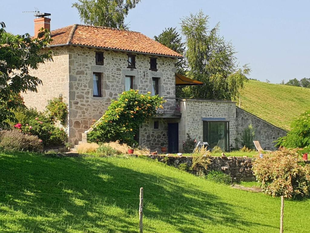 a stone house on a hill with a yard at Hilltop Haven in Parlan in Le Sartre