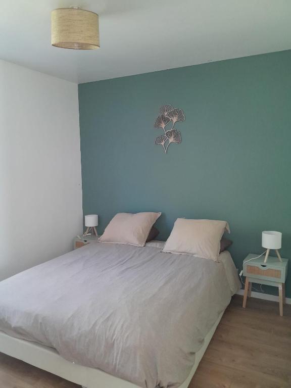 a bedroom with a bed with a blue wall at Maison de pêcheurs in Ault