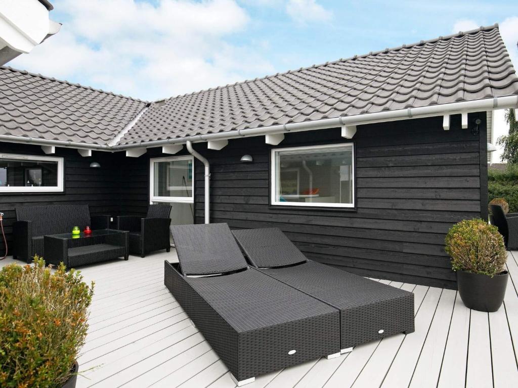 a patio with two lounge chairs on a deck at 5 star holiday home in Faaborg in Bøjden