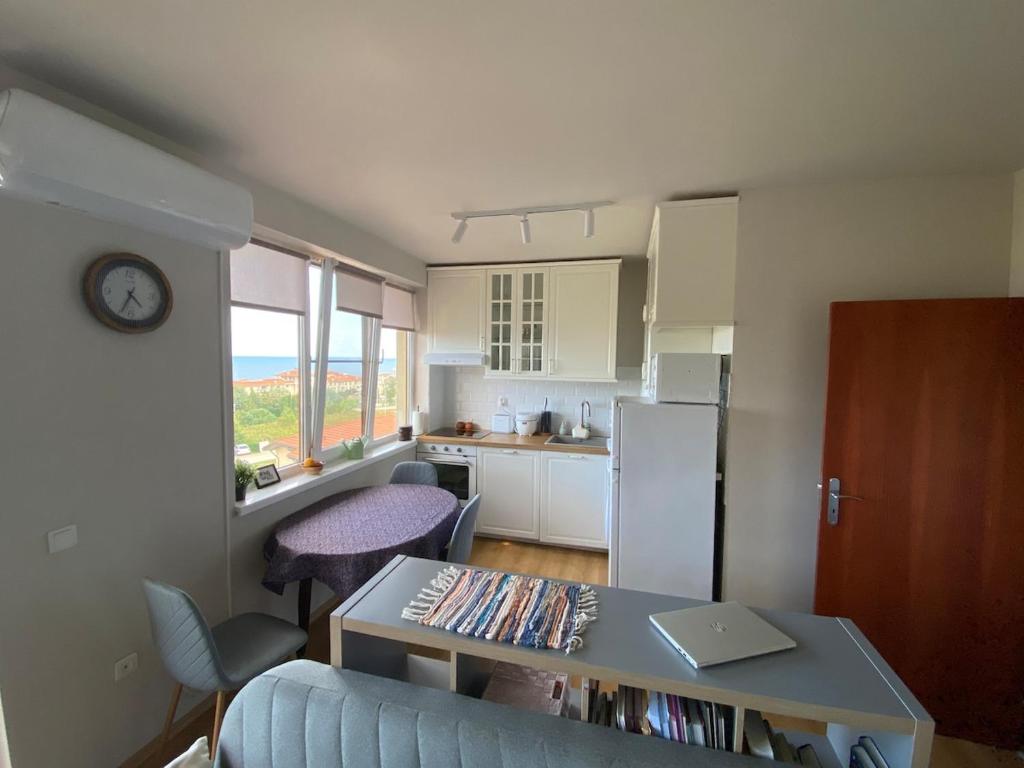 Una sala de estar con una mesa y una cocina. en Sea View Apartment in Byala, en Byala