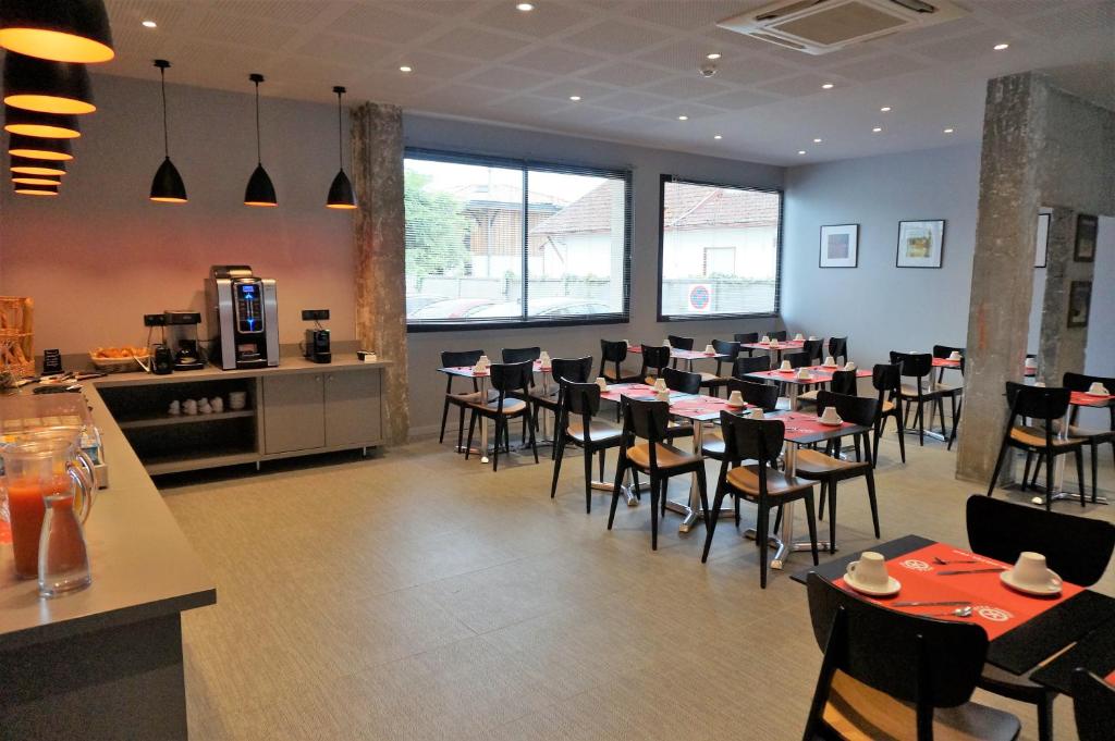 a dining room with tables and chairs in a restaurant at Hôtel Le Nautic in Arcachon