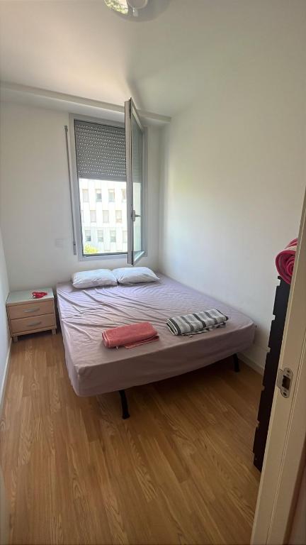 una cama en una habitación con ventana en Habitación mediana, en Santa Coloma