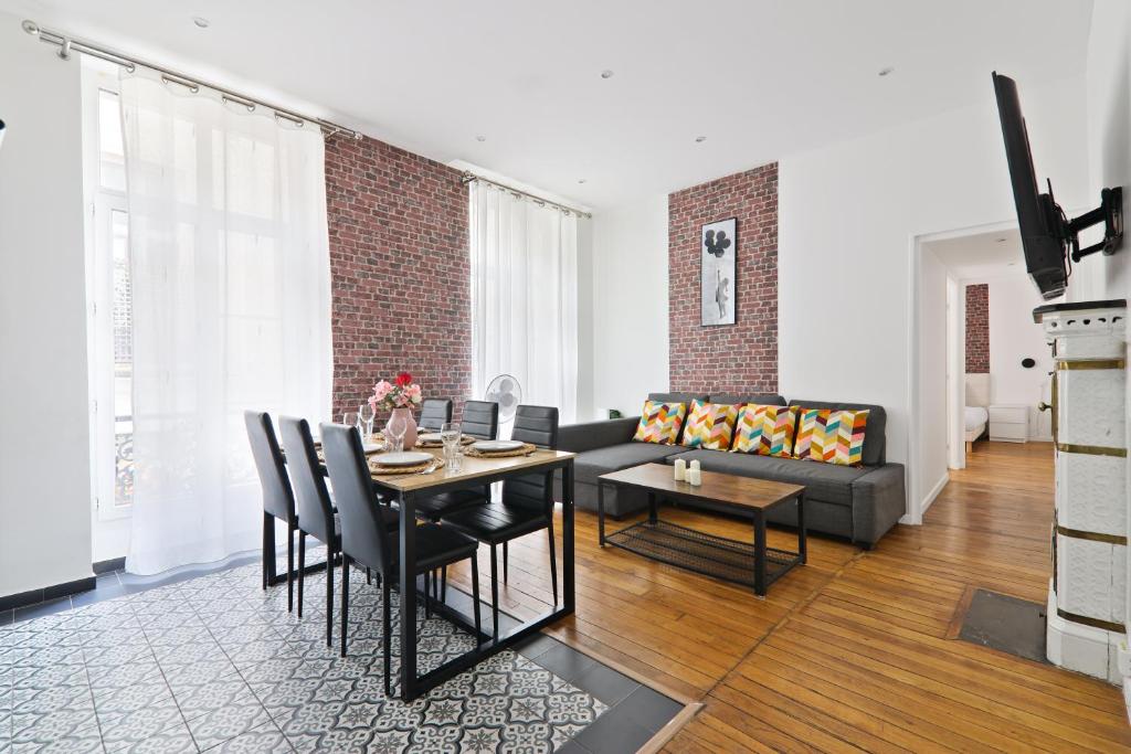 un salon avec une table et un canapé dans l'établissement 2 Bedroom Apartment Île Saint-Louis With Free Netflix, à Paris