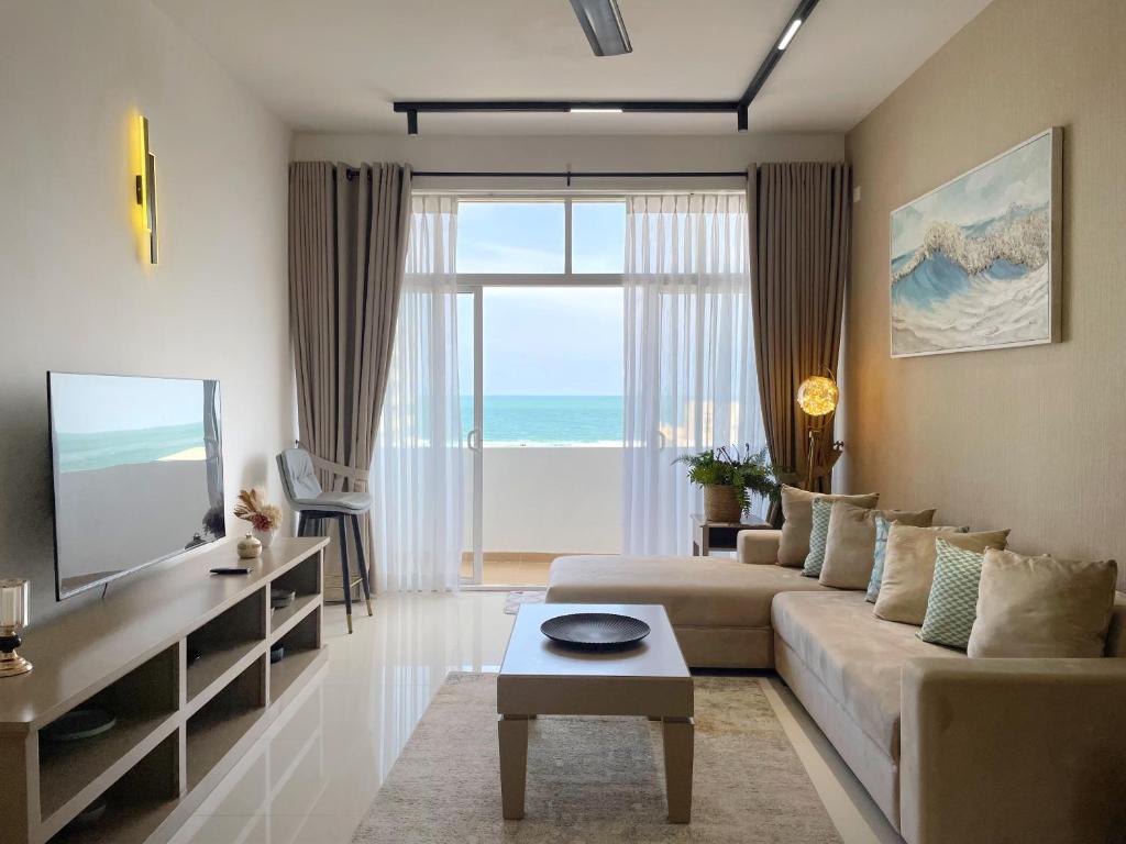a living room with a couch and a large window at Marine Blue Apartment in Dehiwala