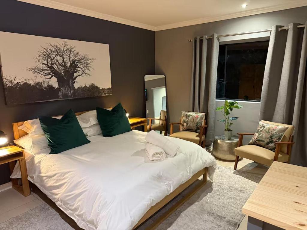 a bedroom with a large white bed with green pillows at 14 Wylant Street in Welgemoed
