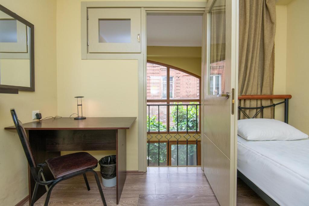 a bedroom with a desk and a bed and a window at Express Hotel in Tbilisi City