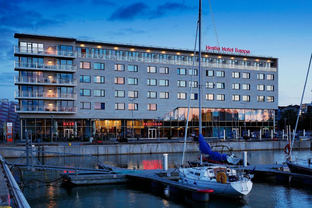 ein Hotel mit einem Boot im Wasser davor in der Unterkunft Hestia Hotel Europa in Tallinn