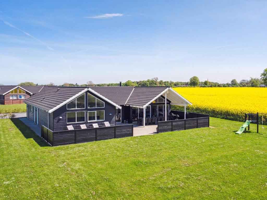 a black house in a field of grass at 5 star holiday home in Bogense in Bogense