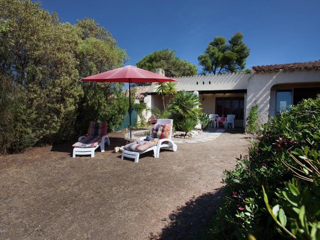 a patio with two chairs and an umbrella at Cosy Holiday Home in Cargèse Corse-du-Sud near Sea in Cargèse