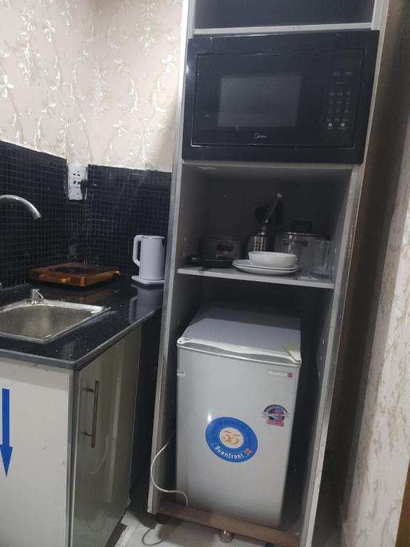 a refrigerator with a microwave on top of it at Marina Apartments in Lagos