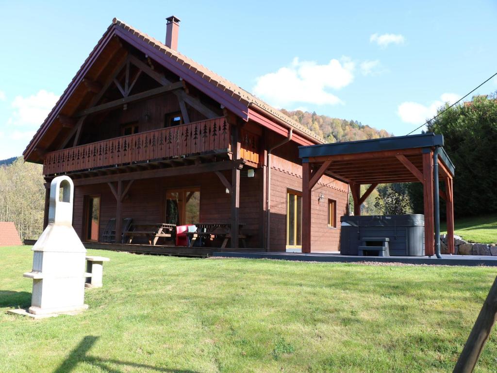 a large house with a porch and a grill at Chalet in Ventron near La Bresse Ski Area in Ventron