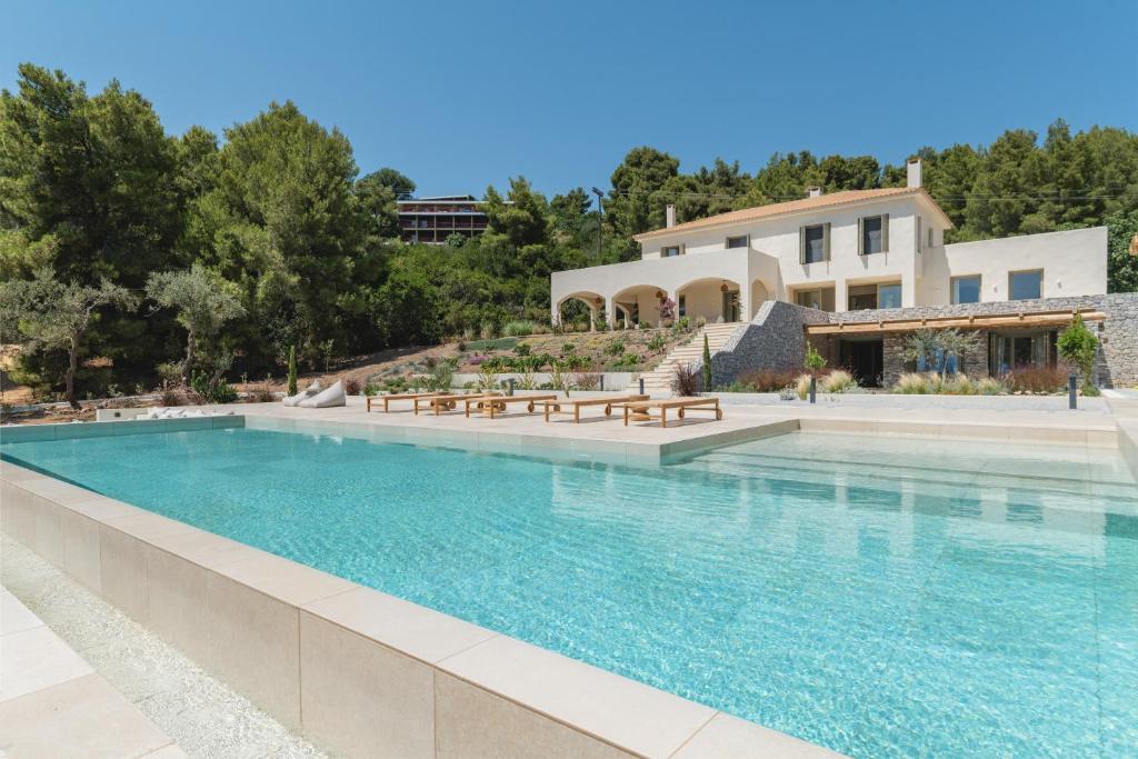 uma grande piscina em frente a uma casa em Villa Delta Skiathos em Skiathos Town