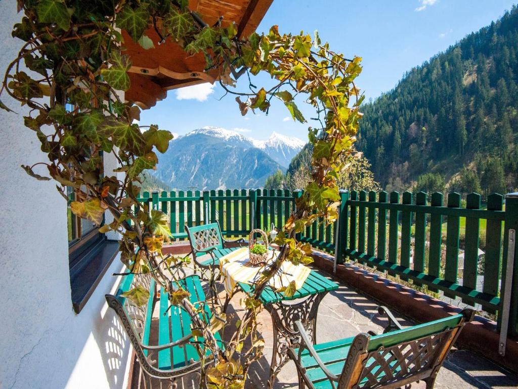 une table et des chaises sur un balcon avec vue sur les montagnes dans l'établissement Comfortable Apartment in Mayrhofen with Garden, à Mayrhofen