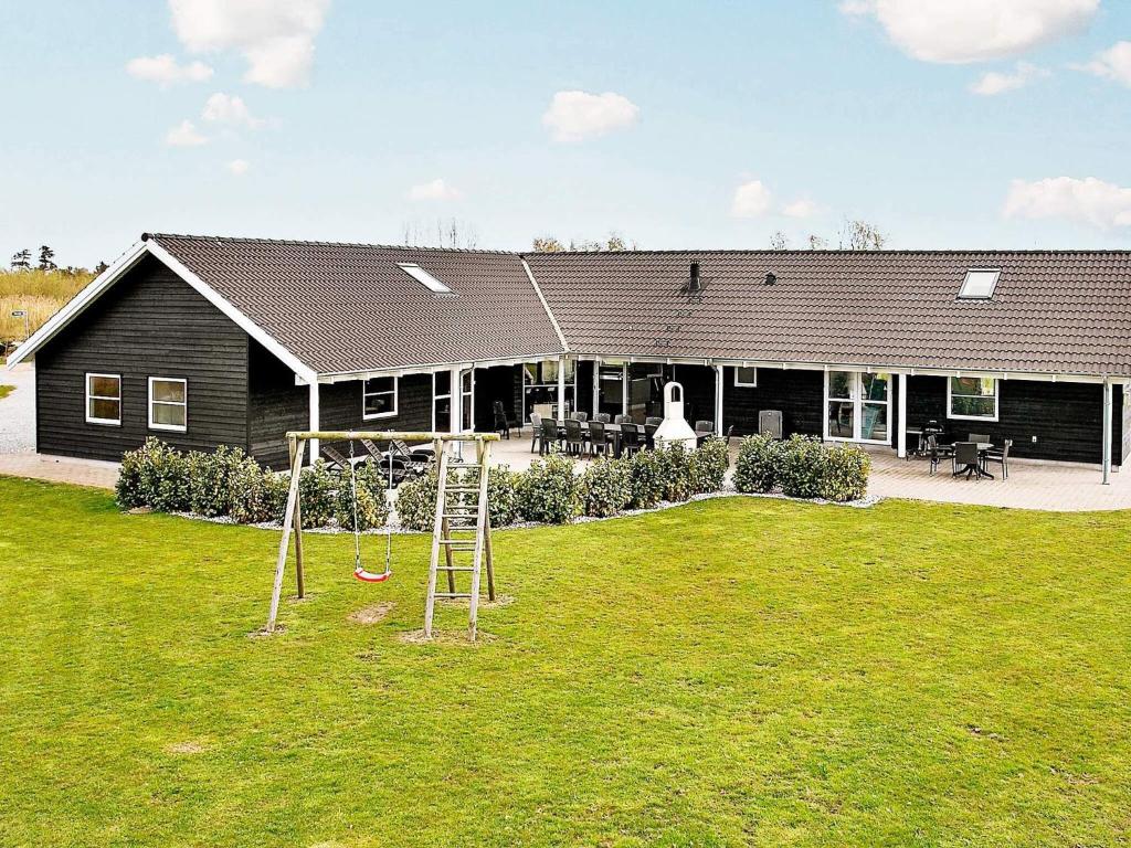 a house with a playground in front of a yard at Luxury Villa with Pool - By Traum Ferienwohnungen in Marielyst