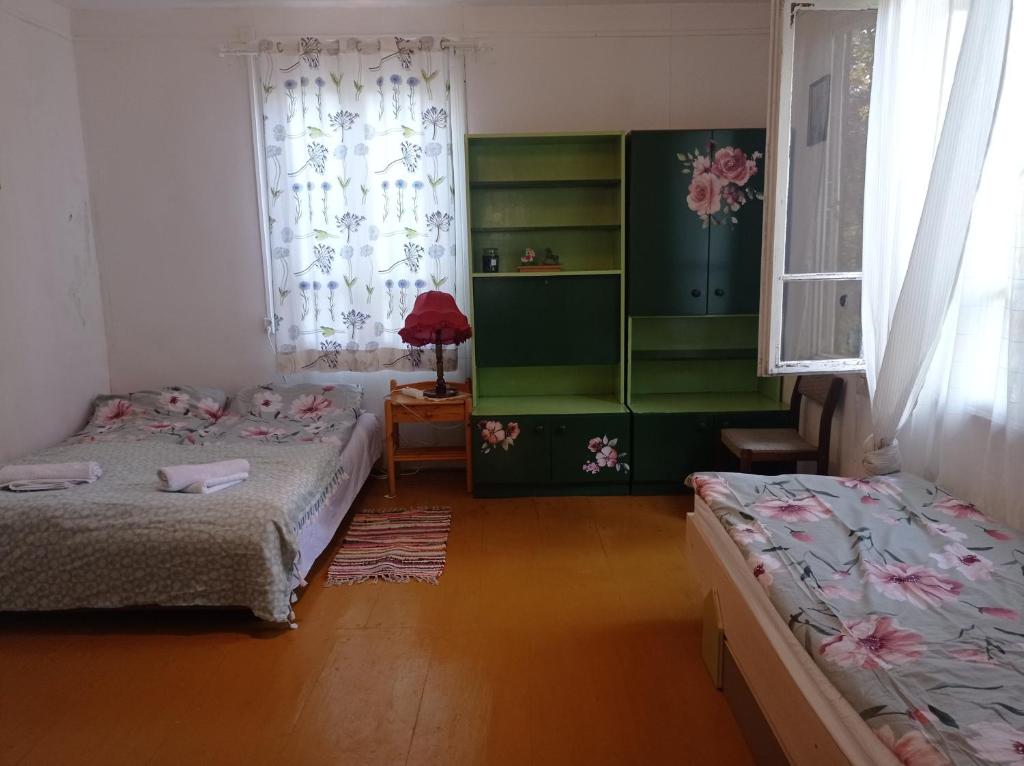 una camera da letto con due letti e una finestra di Siedlisko pod starą lipą a Krzczonów-Wójtostwo