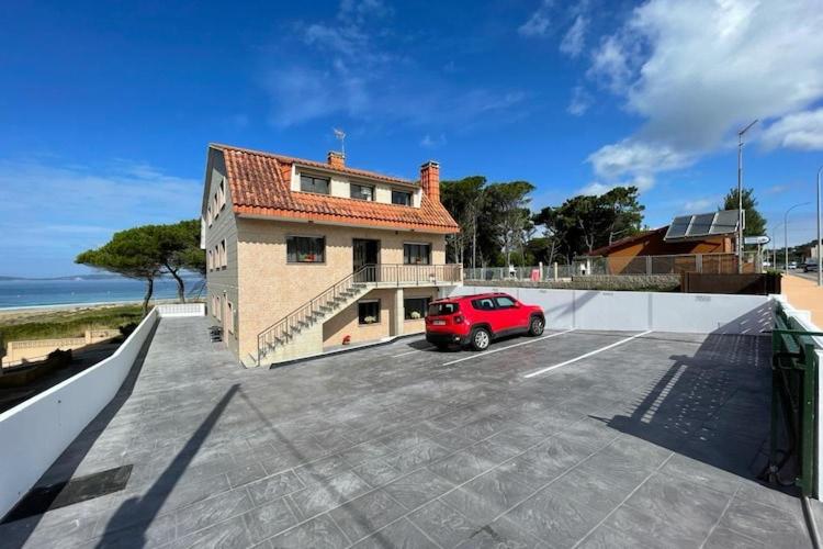 a red car parked in a parking lot next to a building at Apartment with Sea Views in Sanxenxo