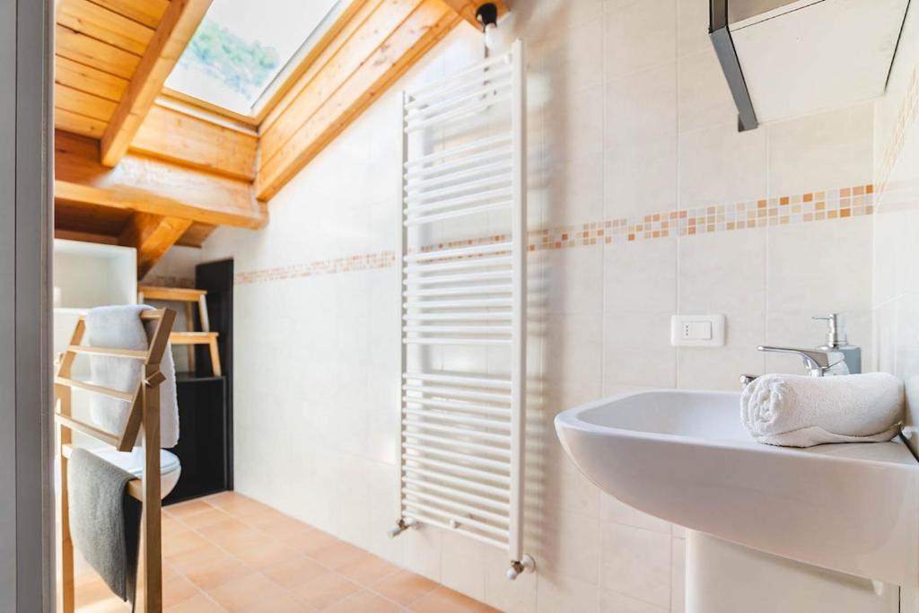 a bathroom with a white sink and a window at Panoramic refuge 5-Baita Lago Blu in Bellano