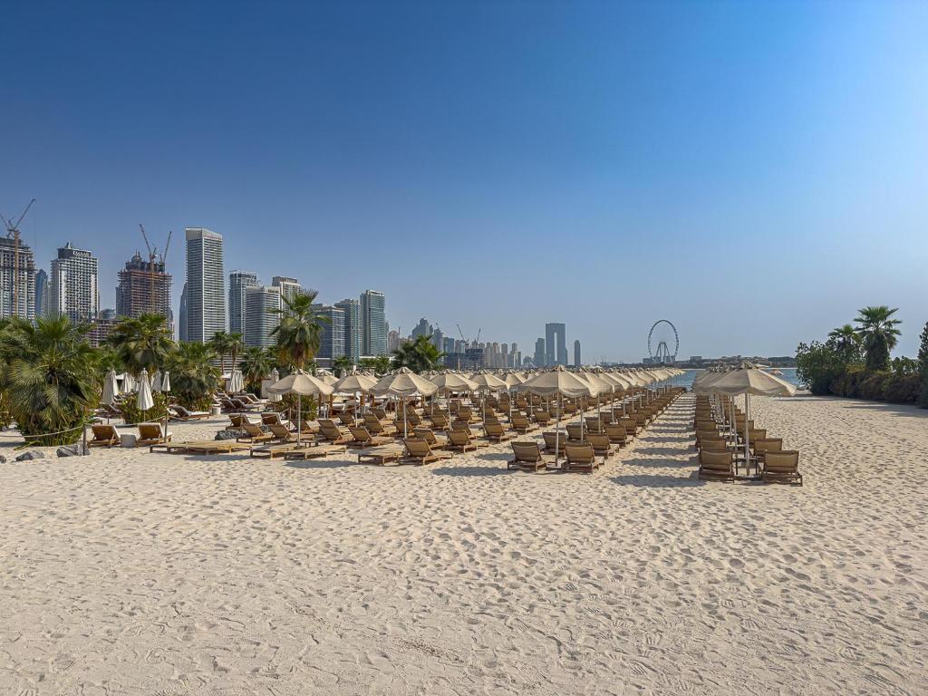 迪拜Seven Palm Jumeirah Studio - Private Beach Access的海滩上一排沙滩椅和遮阳伞