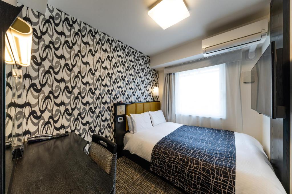 a hotel room with a bed and a wall at APA Hotel Kyoto Ekimae Chuoguchi in Kyoto