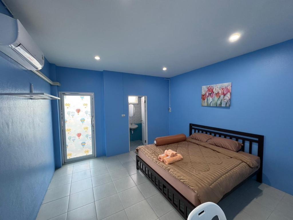 a bedroom with blue walls and a large bed at ปาล์มเฮ้าส์ PalmHouse in Chanthaburi
