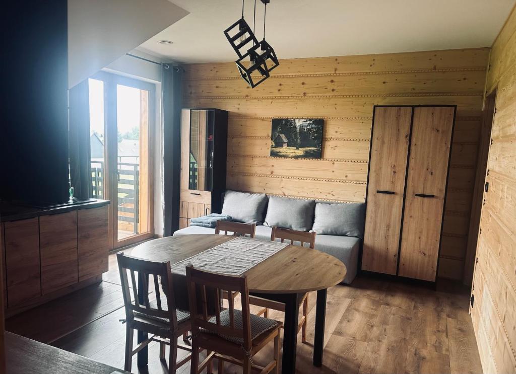 ein Wohnzimmer mit einem Tisch und einem Sofa in der Unterkunft Sky Peak in Stare Bystre