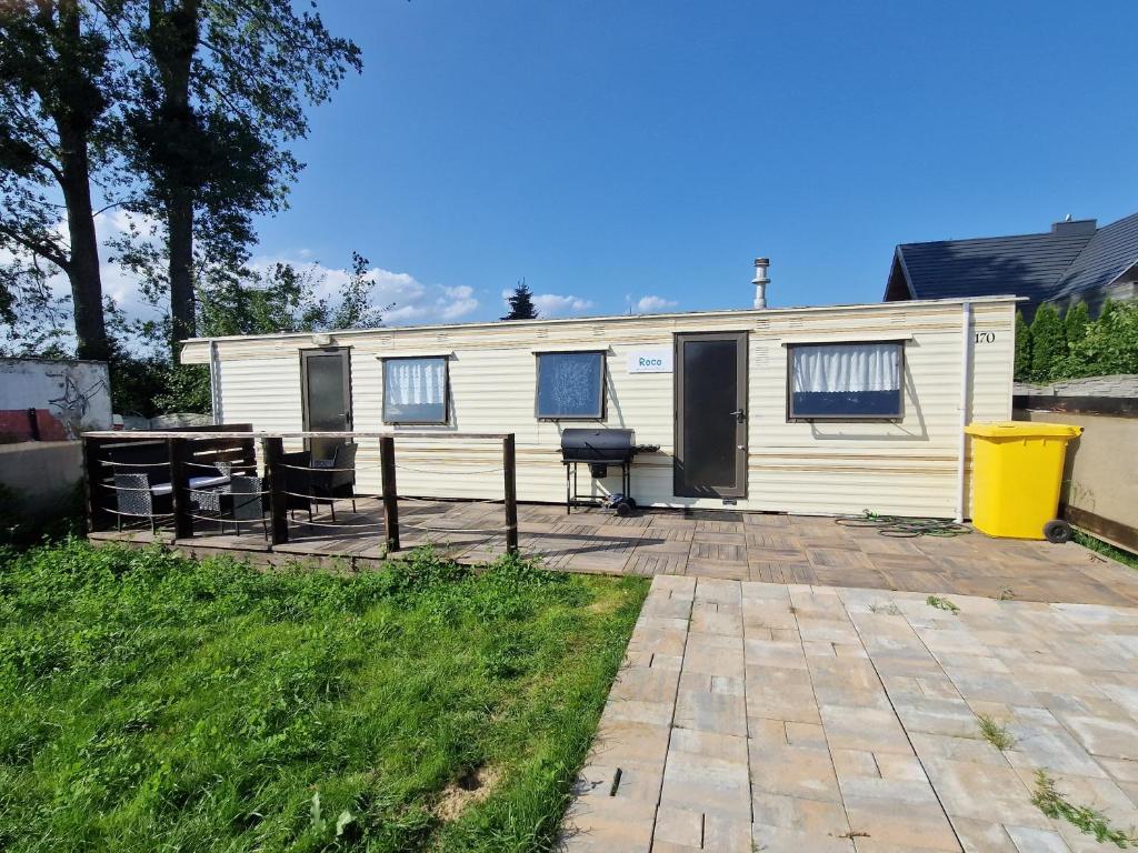 a white trailer with a picnic table and a table at Przyczepa holenderska ROCO in Rewa