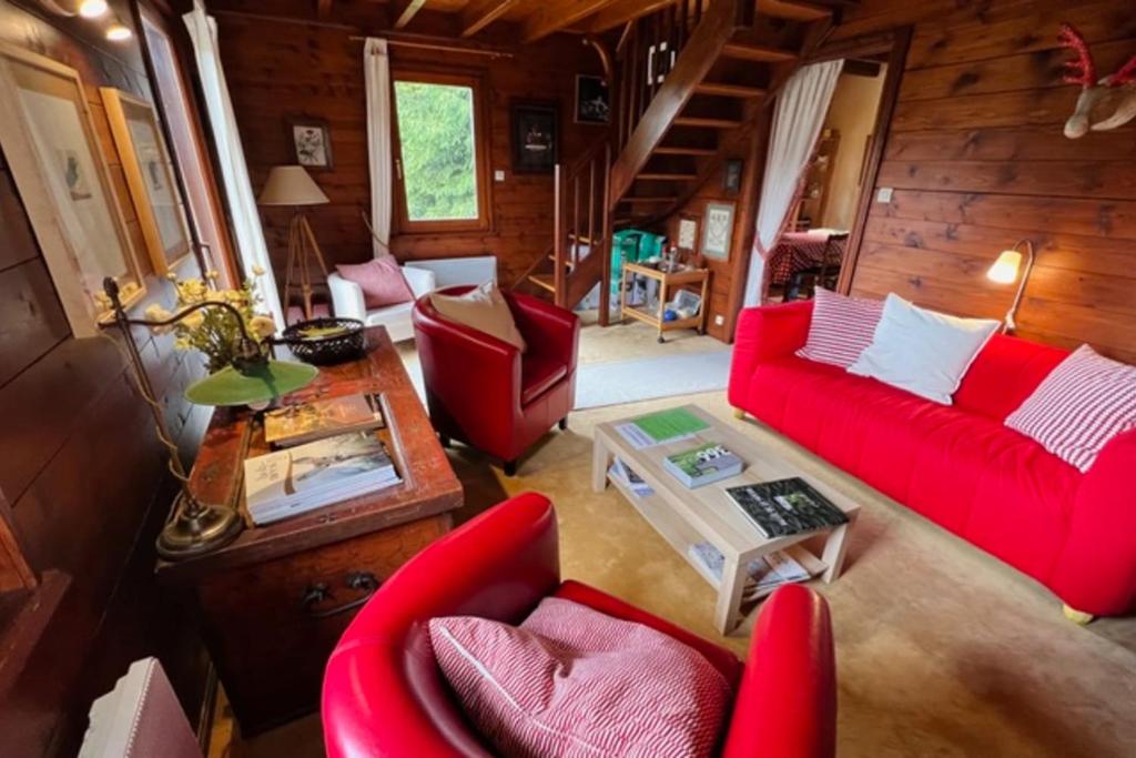 a living room with red couches and a table at Little Paradise hidden from view in Liézey