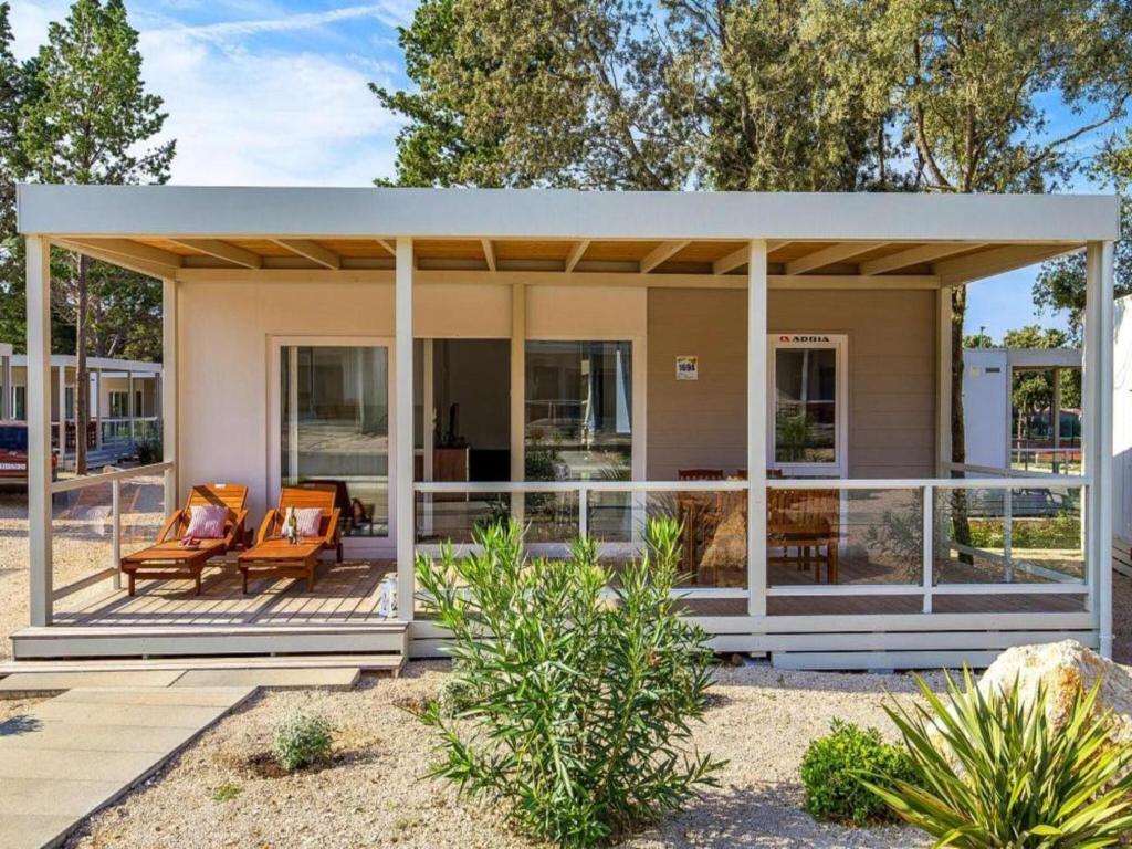 a house with a wrap around porch at Mobile homes Rosemary in camping Strasko, Novalja in Novalja