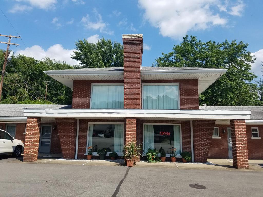 a red brick house with a chimney on top at Melody Motor Lodge in Connellsville