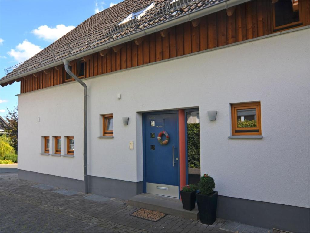 a white house with a blue door and windows at Ferienwohnung im malerischen Eslohe in Eslohe