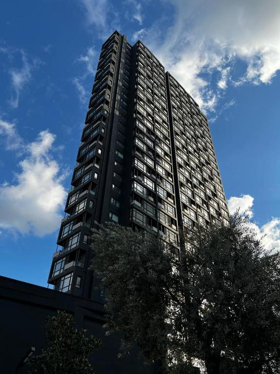a tall building with a tree in front of it at G Tower Residence at Divan Near To Mimar Sinan Metro Station in Istanbul