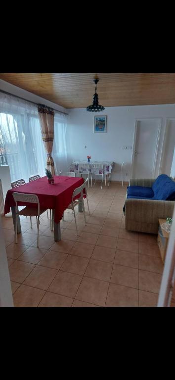 a living room with a red table and a couch at Balatoni nyaraló Badacsony in Badacsonytomaj