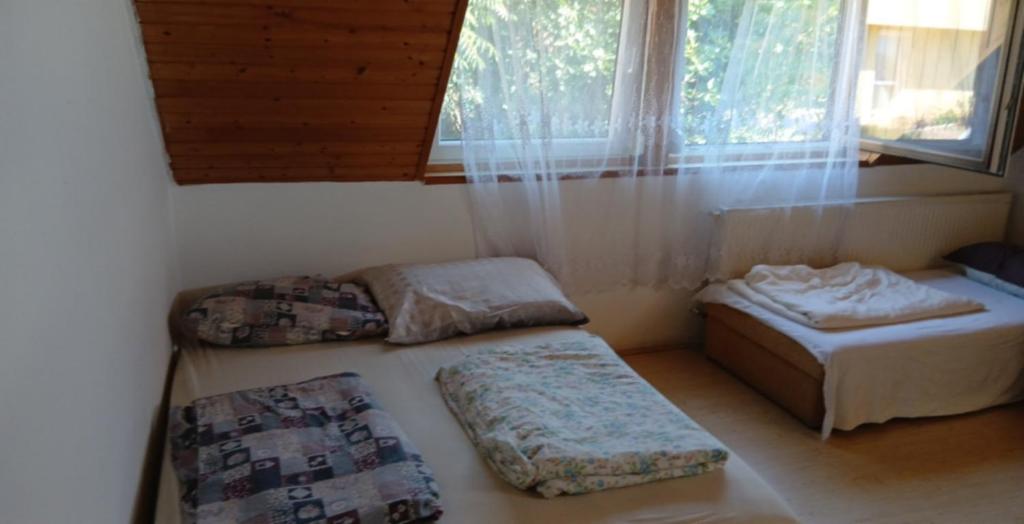 バダチョニトマイにあるBalatoni nyaraló Badacsonyのベッドが2つと窓のある部屋