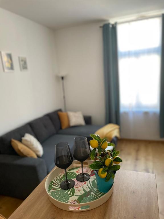 a table with two wine glasses and a plant on it at Mirno in elegantno stanovanje - Parkirišče, Netflix, wifi in Maribor