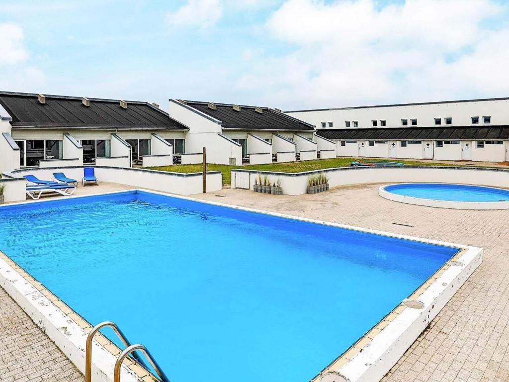 a large swimming pool in front of a building at 6 person holiday home in Brovst in Brovst