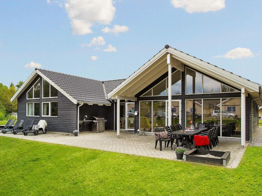 una casa con grandes ventanales y patio en 16 person holiday home in Glesborg, en Fjellerup Strand