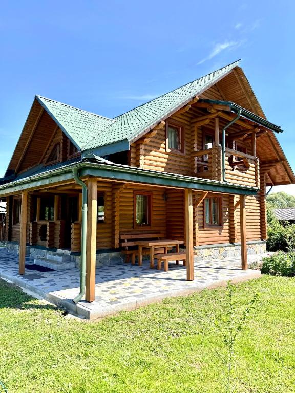 a log cabin with a picnic table in front of it at Смерековий двір in Slavske