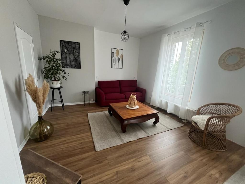 トロワにあるAppartement T2 Troyesの赤いソファとテーブルのあるリビングルーム