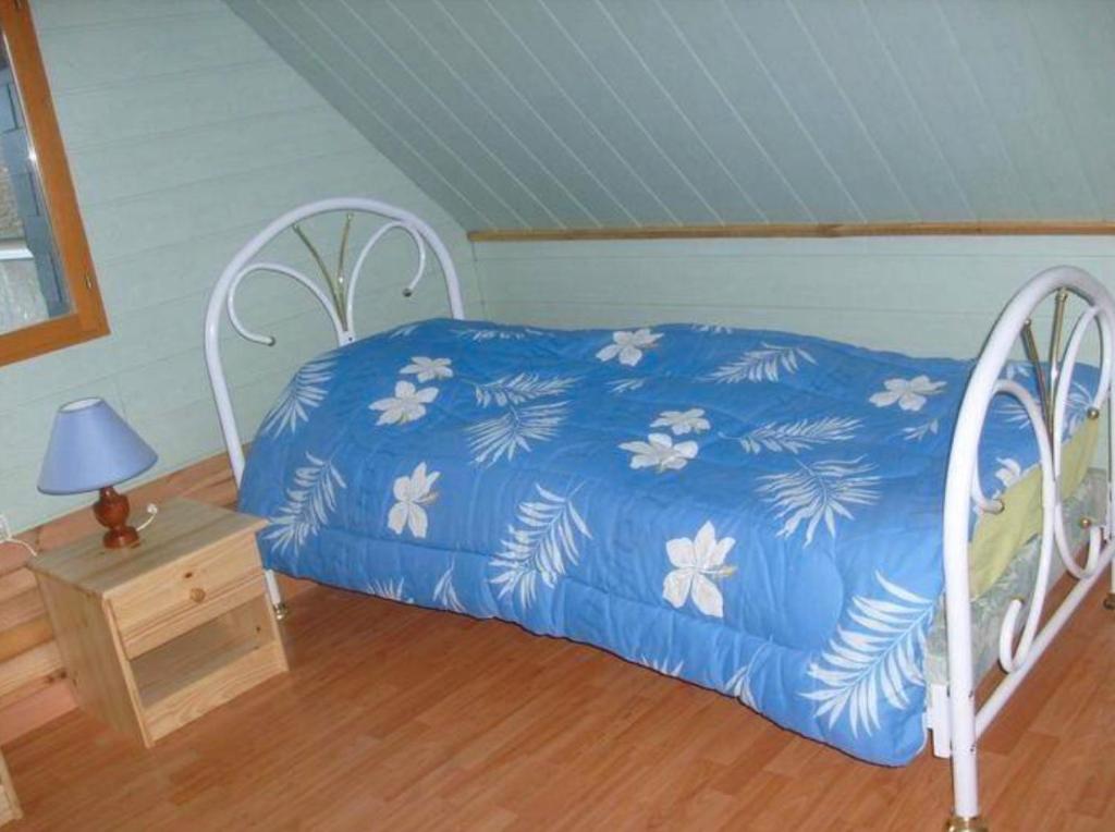 una camera da letto con un letto con un piumone blu di Maison à Saint-Blimont a Saint-Blimont