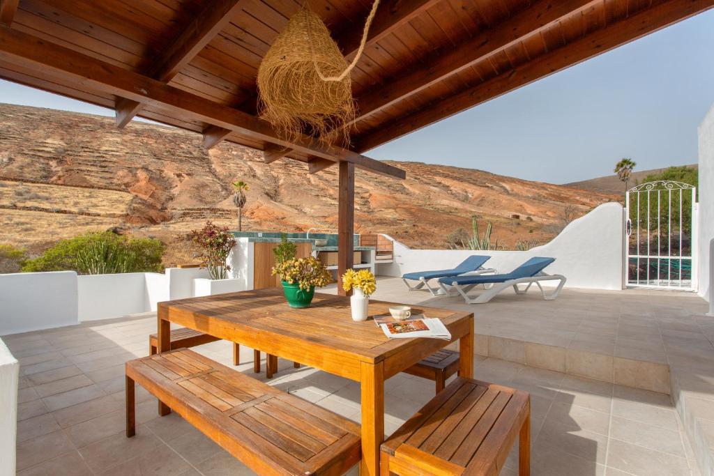 a patio with a wooden table and benches at El Refugio de Churchill in Máguez