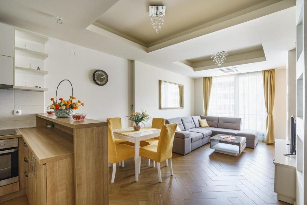 Una cocina y una sala de estar con un sofá y una mesa. en Cozy City Center Studio, en Babalonija